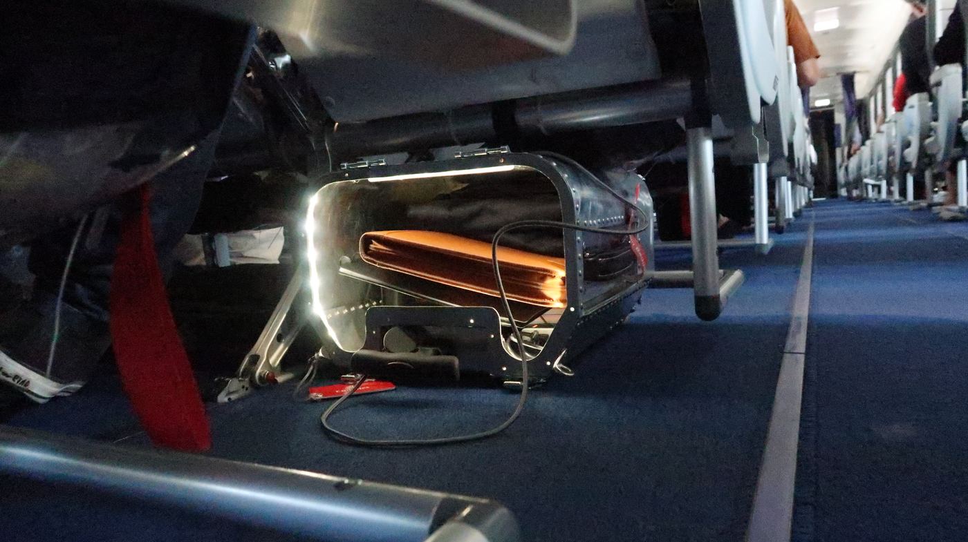The Taildragger under an airline seat, lit from inside