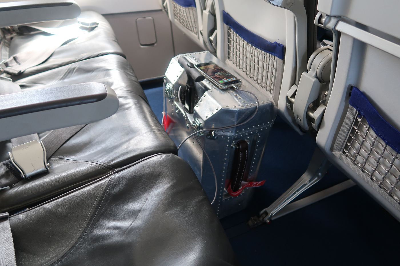 The Taildragger standing next to a seat, charging a phone from its USB port