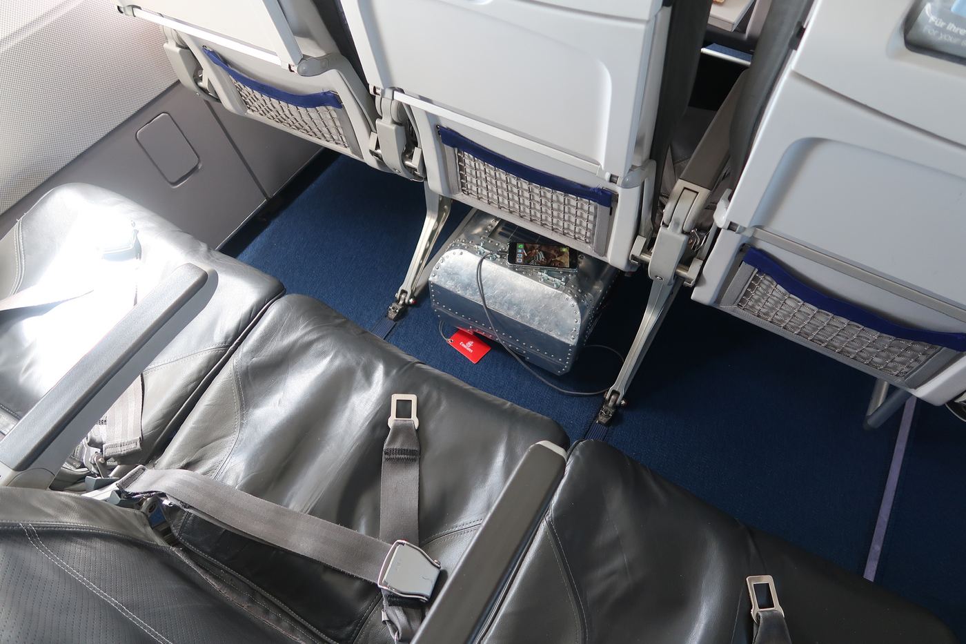 The Taildragger stowed under the seat in front, charging a phone